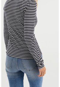 Långärmad topp med växlande marinblå och vita ränder, tillverkad av ett mjukt material, med en figurnära design och rund halsringning.