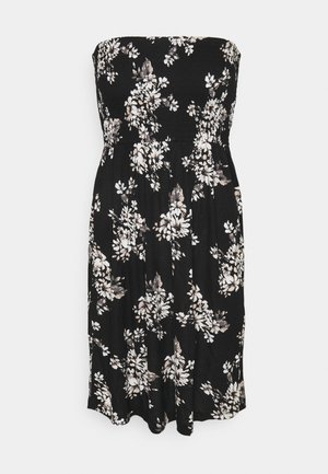 Black strapless dress with a smocked bodice, featuring a floral pattern in white and beige. Flows gently at knee length with a soft texture.