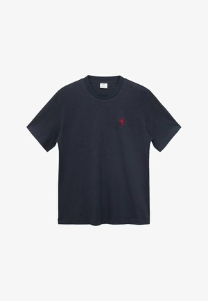 Tmavomodré tričko s krátkym rukávom vyrobené z mäkkej bavlny, so malou červenou vyšívanou nášivkou na ľavej strane hrude.