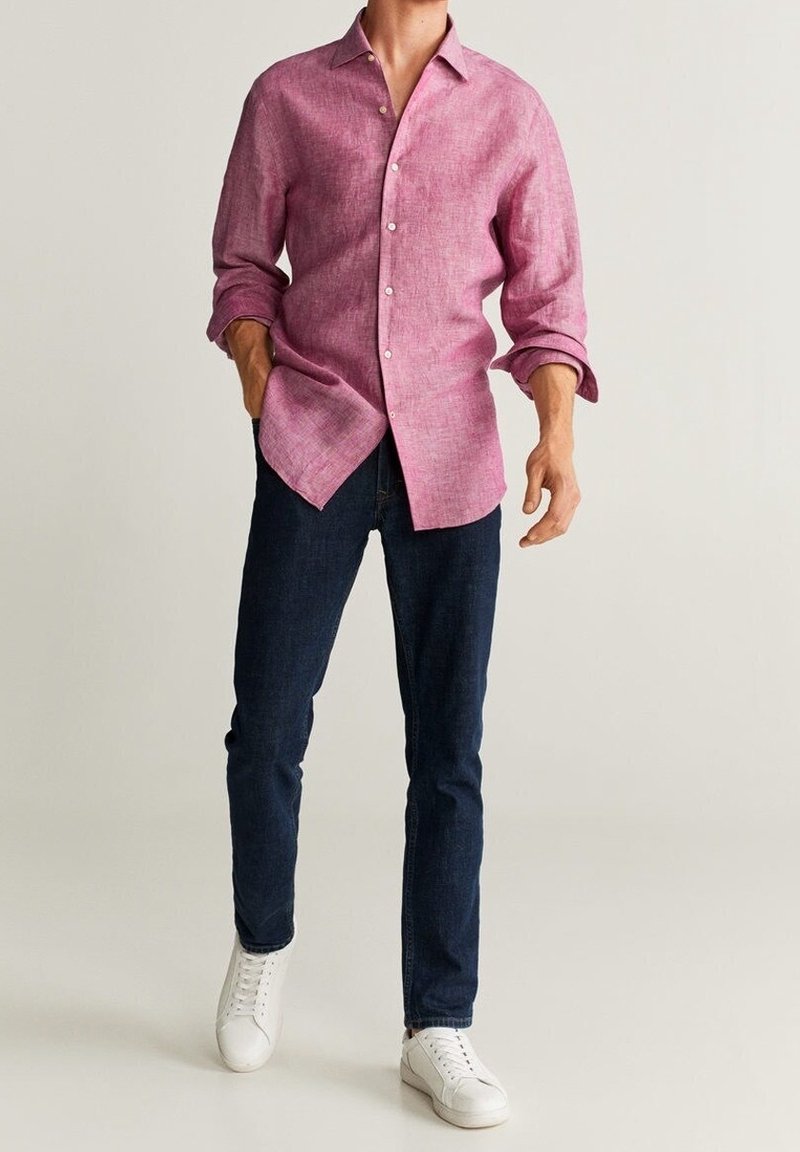 Lichtgewicht roze linnen shirt met lange mouwen, knopen, gecombineerd met donkerblauwe jeans en witte sneakers.