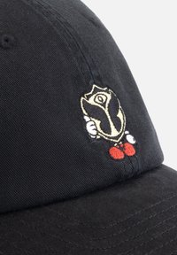 Zwarte pet met een geborduurd ontwerp van een personage dat een schild vasthoudt, versterkt met rode en witte details. Gemaakt van katoen, met een gestructureerde vorm.