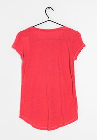 Camisa corta de manga corta roja con un dobladillo ligeramente curvado, fabricada en tejido ligero. Presenta un escote redondo y costuras planas.