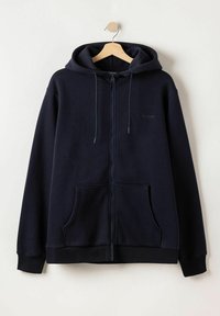 Marineblauwe zip-up hoodie met een trekkoordcapuchon, kangoeroe pockets en geribbelde manchetten. Gemaakt van zacht materiaal en met een subtiele merklocatie.