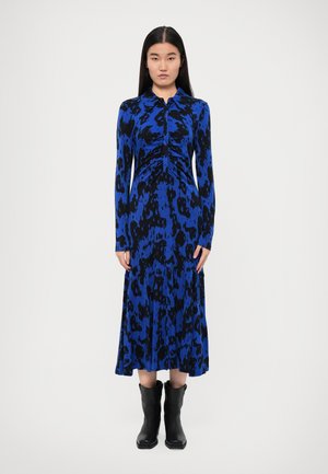 Long-sleeve blue and black patterned dress with a button-up collar and gathered detail at the waist, paired with black ankle boots.