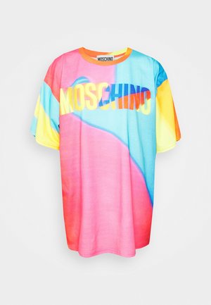 T-paita, jossa on pinkin, sinisen ja keltaisen liukuvärit, ja "Moschino"-logo. Yhdistetty sinisiin farkkuihin ja mustiin korkokenkiin.