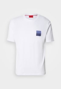 White cotton T-shirt with short sleeves, featuring a blue and purple square chest pocket displaying the "HUGO" logo in white. Red neck label.