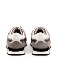 Sneaker in suede grigio con dettagli bianchi e suola nera, caratterizzate da un design arrotondato e collo imbottito per il comfort. Logo sul tallone.