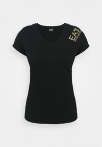 Svart V-ringad t-shirt i mjuk bomull, med korta upprullade ärmar och en gul logotyp tryckt på vänster axel.