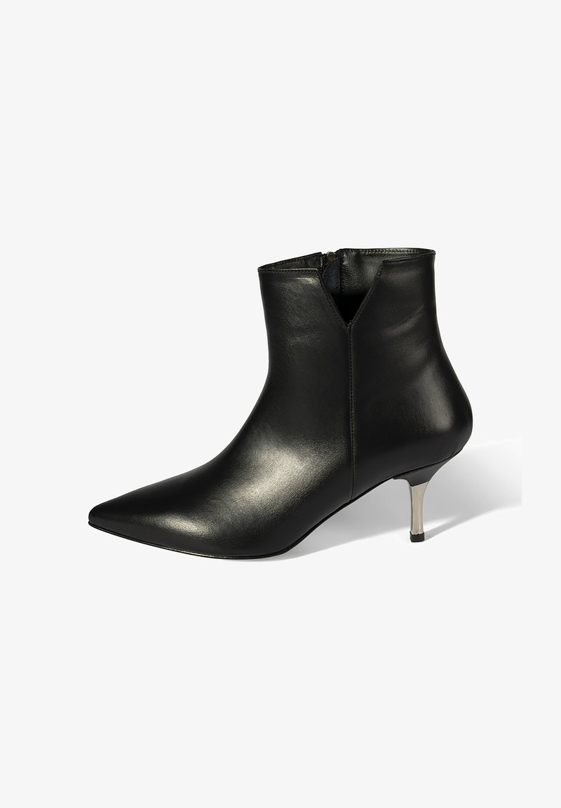 Bottes chevilles en cuir noir avec bout pointu, fermeture éclair et petit talon métallique. Texture lisse avec un design élégant et moderne.