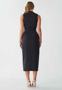 Melnas midi kleitas ar piegulošu augšdaļu un jostasvietu, kas piemīt elegants dizains, gluda tekstūra un taisns apakšmalas griezums ar centrālo šķirumu.