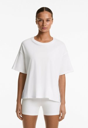 Witte oversized t-shirt gemaakt van lichtgewicht katoenen stof, met een ronde halslijn en korte mouwen, met een ontspannen pasvorm en eenvoudig ontwerp.