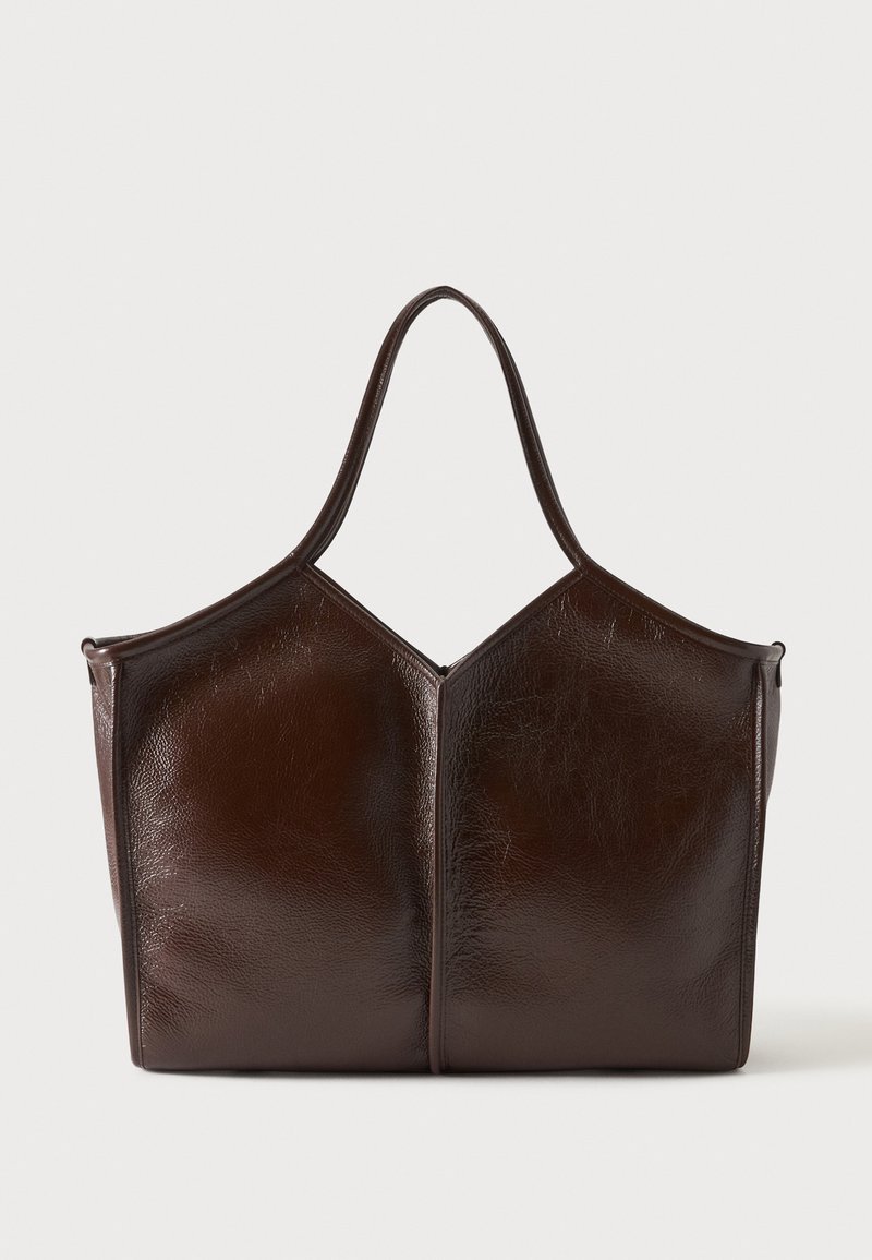 Sac cabas en cuir marron foncé avec une forme géométrique structurée et des poignées doubles sur un fond clair uni.