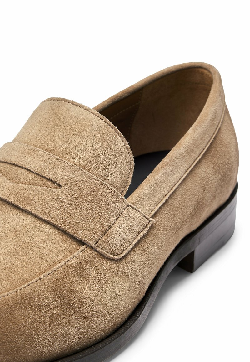 Lichtbruine suede instapper met een ronde neus en een slip-on ontwerp. Beschikt over een enkele band met een uitsnijdetail en een lage houten hak.