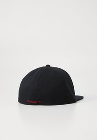 Casquette noire en coton avec une couronne ronde et une visière plate. Inscription rouge "EST. HUGO 1993" à l'arrière. Design minimaliste, sans motifs.