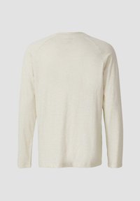 Langärmliges, cremefarbenes Shirt aus weichem Stoff. Hat ein einfaches Design mit Raglanärmeln und einem abgerundeten Halsausschnitt.
