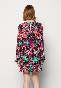 Vestido floral de mangas largas, con un patrón multicolor sobre un fondo negro, un dobladillo con volantes y una abertura en forma de llave en la parte de atrás.
