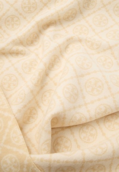 Crèmekleurige stof met een zachte, gestructureerde oppervlakte, voorzien van een subtiel patroon van cirkelvormige ontwerpen en diamantroosters in lichtere tinten.