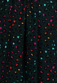 Tmavá tkanina s vícebarevným leopardím potiskem se skvrnami v červené, fialové, tyrkysové a oranžové barvě na černém pozadí.