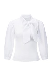 Weiße Bluse mit hohem Kragen und großer Schleife am Hals. Verfügt über einen gerippten Körper und gepuffte Ärmel mit elastischen Bündchen. Glatte Textur.