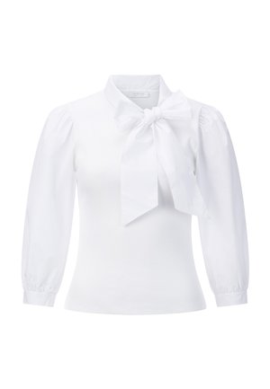 White blouse with a high collar and large bow at the neck. Features ribbed body and puffed sleeves with elastic cuffs. Smooth texture.