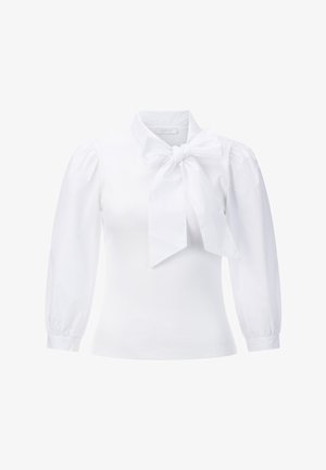 Blusa bianca con colletto alto e grande fiocco al collo. Presenta un corpo a coste e maniche a sbuffo con polsini elastici. Texture liscia.