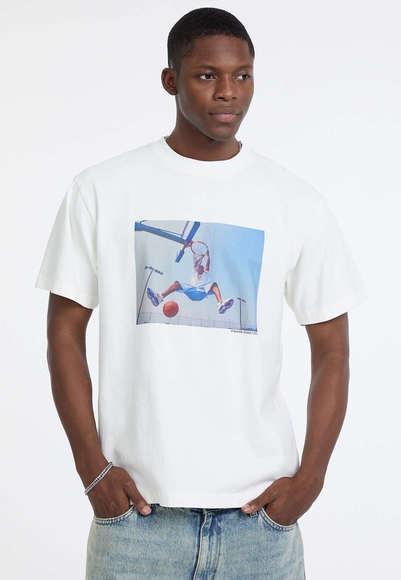 Witte katoenen t-shirt met een grafische print van een basketballer in de lucht, met blauwe en rode accenten in het ontwerp. Casual pasvorm.