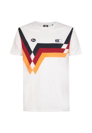 T-shirt en coton blanc présentant des motifs en chevron diagonaux multicolores en bleu foncé, rouge, orange et jaune, avec un accent de logo circulaire.