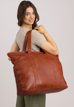Borsa a tracolla in pelle marrone con grande forma rettangolare, superficie testurizzata e due spallacci robusti. Presenti cuciture e dettagli notevoli.