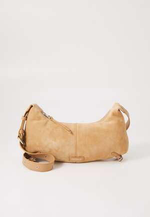 Sac à main en suède camel avec une forme arrondie, doté d'une fermeture éclair, d'une bandoulière ajustable et d'un logo en patch sur le devant. Texture lisse.