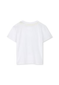 Camiseta blanca de manga corta hecha de algodón, con un diseño sencillo, cuello redondo y un acento amarillo claro en el cuello.
