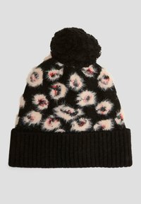 Gebreide beanie met zwarte en crèmekleurige luipaardvlekken, met een fluffy textuur en een zwarte geribbelde manchet. Afgewerkt met een ronde zwarte pompon bovenop.