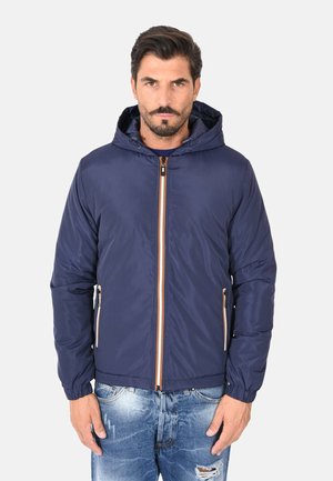Giacca con cappuccio blu navy con zip frontale, dettagli arancioni a contrasto e tasche laterali; realizzata in materiale liscio e leggero.