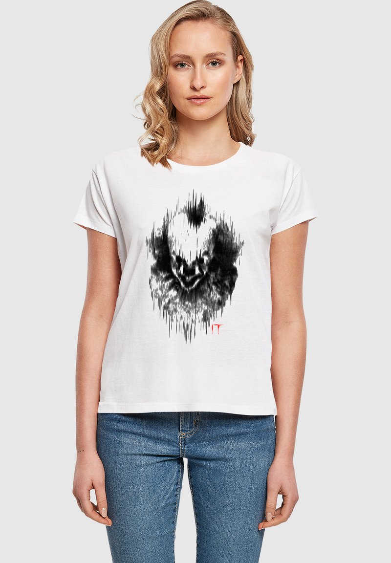 Weißes Baumwoll-T-Shirt mit einem schwarzen Grafikdesign, das einem Clownsgesicht mit Klangwellenmustern ähnelt; kurze Ärmel und lockerer Schnitt.
