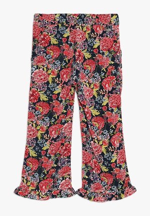 Pantalon à imprimé floral avec de grandes fleurs rouges et roses, des feuilles vertes, un fond bleu marine, et des ourlets à volants.