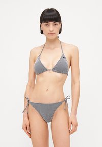 Svart og hvit gingham bikini med halterneck topp og sideknyting nederst, med tynne stropper og glatt overflate.