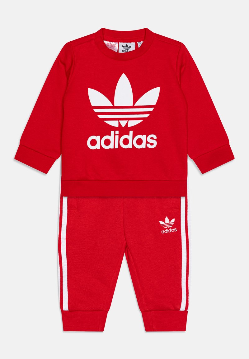 Rotes Adidas zweiteiliges Trainingsanzug mit weißem Logo. Besteht aus einem langärmeligen Pullover mit Rundhalsausschnitt und passenden Hosen mit weißen Seitenstreifen und Bündchen.