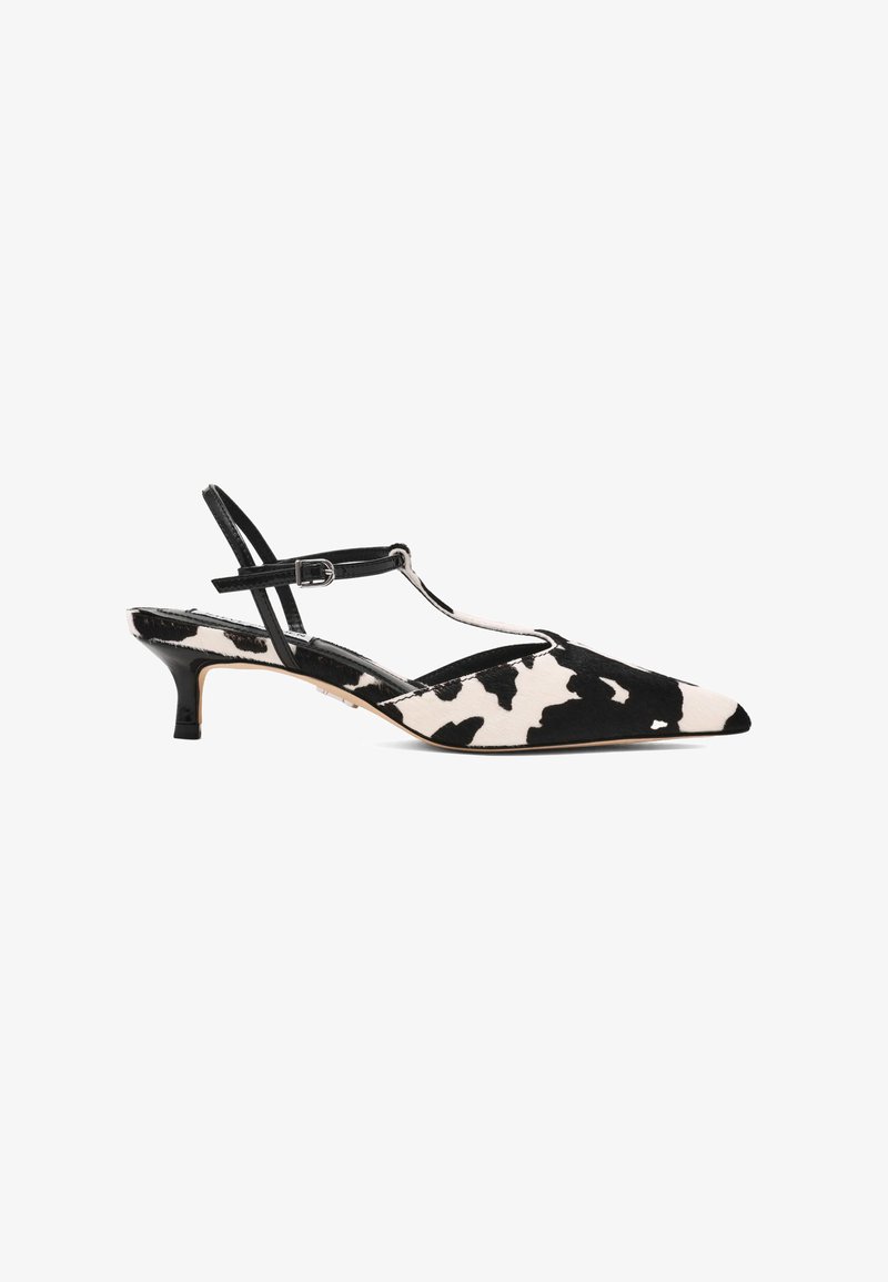Escarpins slingback à bout pointu en imprimé vache noir et blanc, avec une fine bride de cheville et un petit talon noir. Texture douce.
