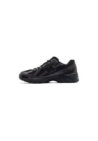 Black athletic shoes with a mesh and synthetic upper, rounded toe, lace closure, cushioned sole, and textured side panels.