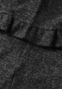 Tissu en laine gris foncé avec un détail de couture pliée créant une texture subtile de volant sur la surface.