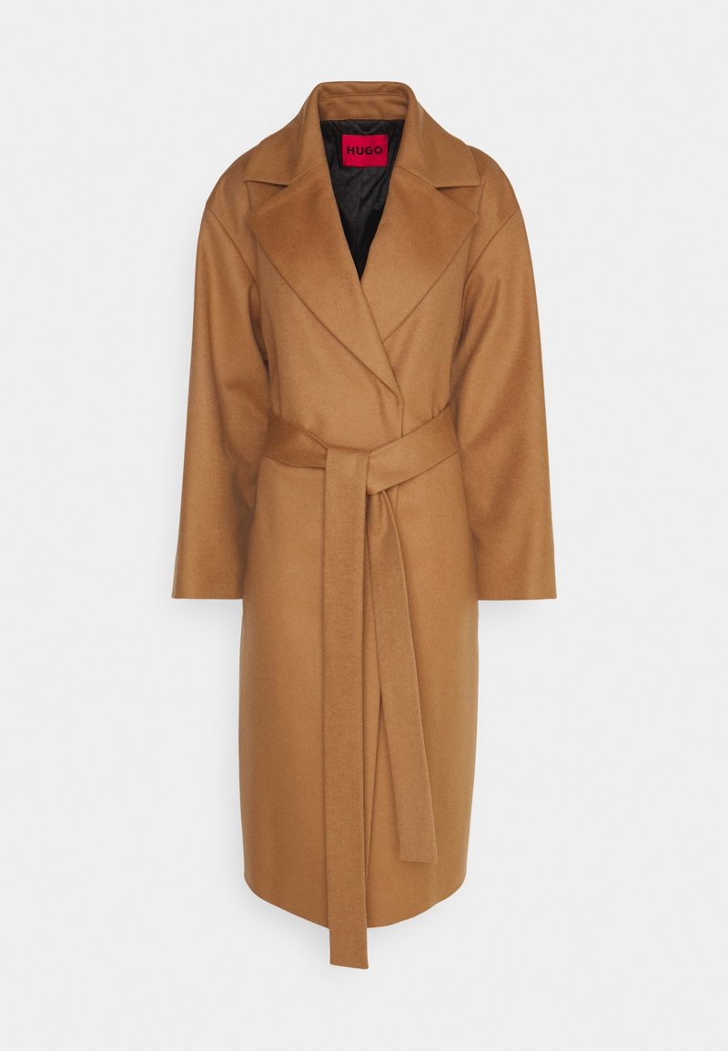 Long manteau camel marron enveloppant avec larges revers et ceinture assortie, présenté à plat avec doublure intérieure noire et étiquette rouge HUGO à l'intérieur du col.