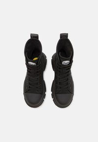 Sneakers neri alte in tela, con punta in gomma, suole spesse e sistema di allacciatura. Comprendono un tassello per il tallone e dettagli con logo.