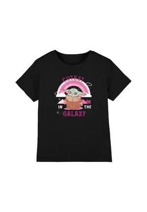 Black short-sleeve shirt with cartoon green alien wearing a brown coat, pink rainbow, stars, and text "Cutest in the Galaxy."