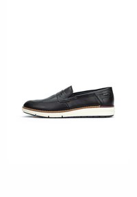 Zapato negro de piel deslizante con punta redondeada, detalles de costura y suela de goma blanca contrastante con un acento marrón.