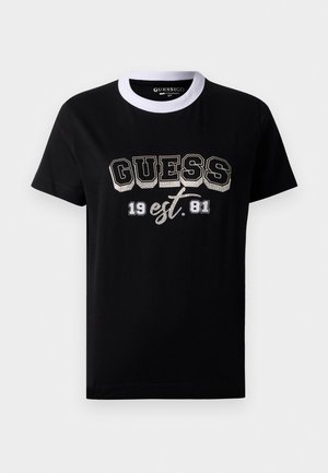 T-shirt nera a maniche corte con colletto girocollo bianco, caratterizzata dalla scritta "GUESS" in grandi lettere in grassetto e "19 est. 81" stampato sul davanti.