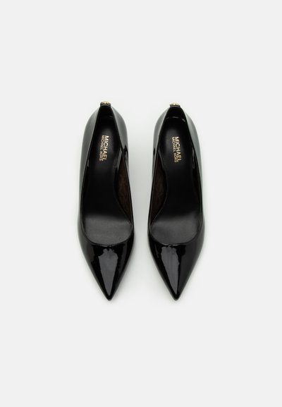 Des escarpins en cuir verni noir à bout pointu, avec une surface lisse et un logo de marque subtil à l'intérieur de la chaussure.
