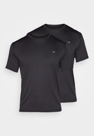Deux t-shirts noirs à manches courtes en tissu léger et lisse, avec un col rond et un petit logo blanc sur la poitrine.