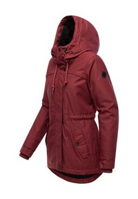 Giacca isolata rossa con cappuccio, cordini regolabili, tasche con bottone e polsini a coste. Presenta una morbida fodera nera e un'etichetta con il logo.