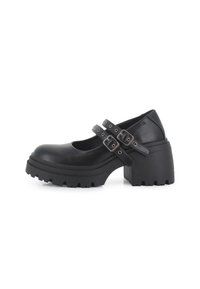 Zapatos de tacón alto negros con una plataforma gruesa, punta redondeada y dos correas ajustables con hebillas metálicas. Suela de goma texturizada.