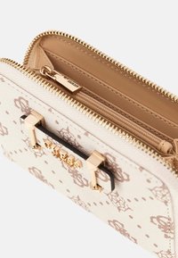 Portafoglio beige con motivo, zip dorato, tasca con zip interna e placca con logo Guess in oro sulla parte anteriore.