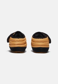 Brune og sorte slip-on sko med et puffy, quiltet design, blødt materiale og rund form; har en sort gummisål for godt greb.